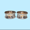 Servilleteros de metal plateado colocados sobre servilletas marrón.