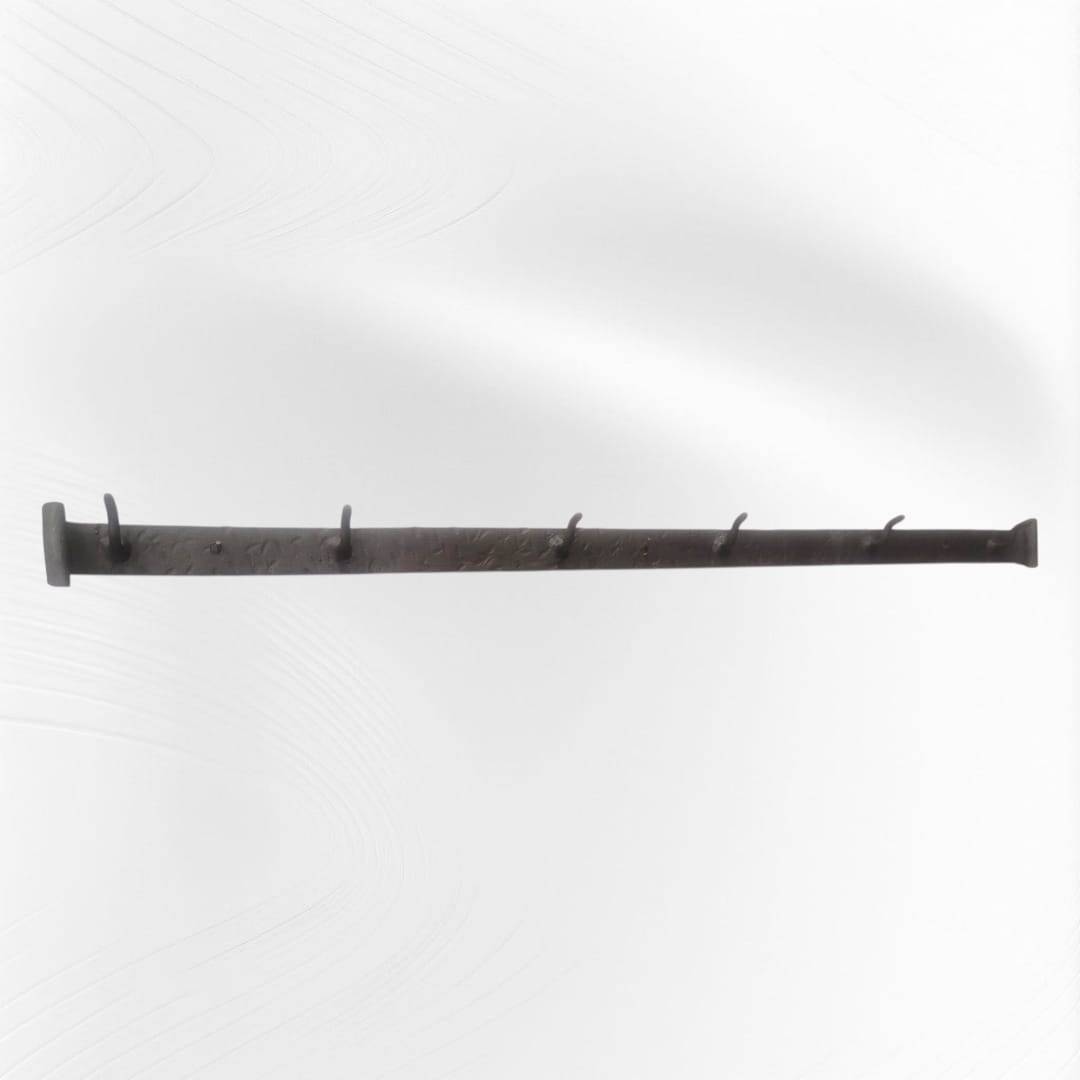 Soporte de forja antigua instalado con cucharones colgantes, perfecto para decoración de cocina estilo rústico o tradicional.
