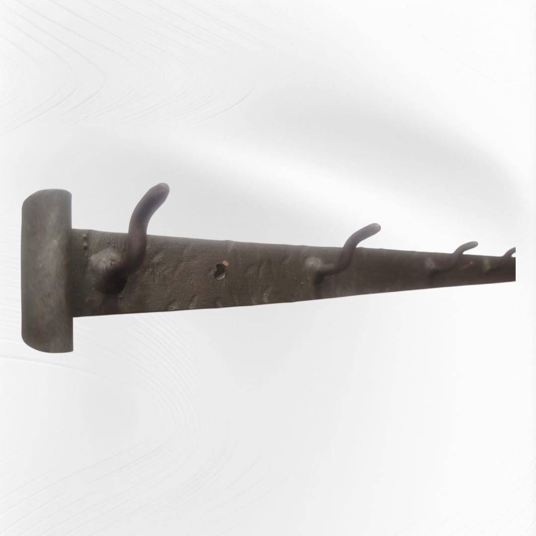 Detalle del soporte de forja antigua mostrando los ganchos de hierro forjado, ideal para colgar utensilios o elementos decorativos.