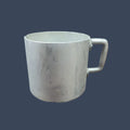 Persona sosteniendo la taza de aluminio mientras disfruta de una bebida caliente al aire libre.