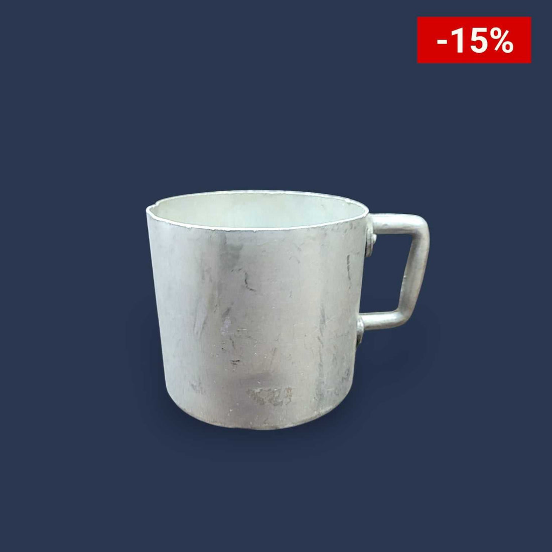 Persona sosteniendo la taza de aluminio mientras disfruta de una bebida caliente al aire libre.