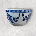 Detalle de la decoración en azul sobre porcelana blanca, resaltando los intrincados patrones hechos a mano.