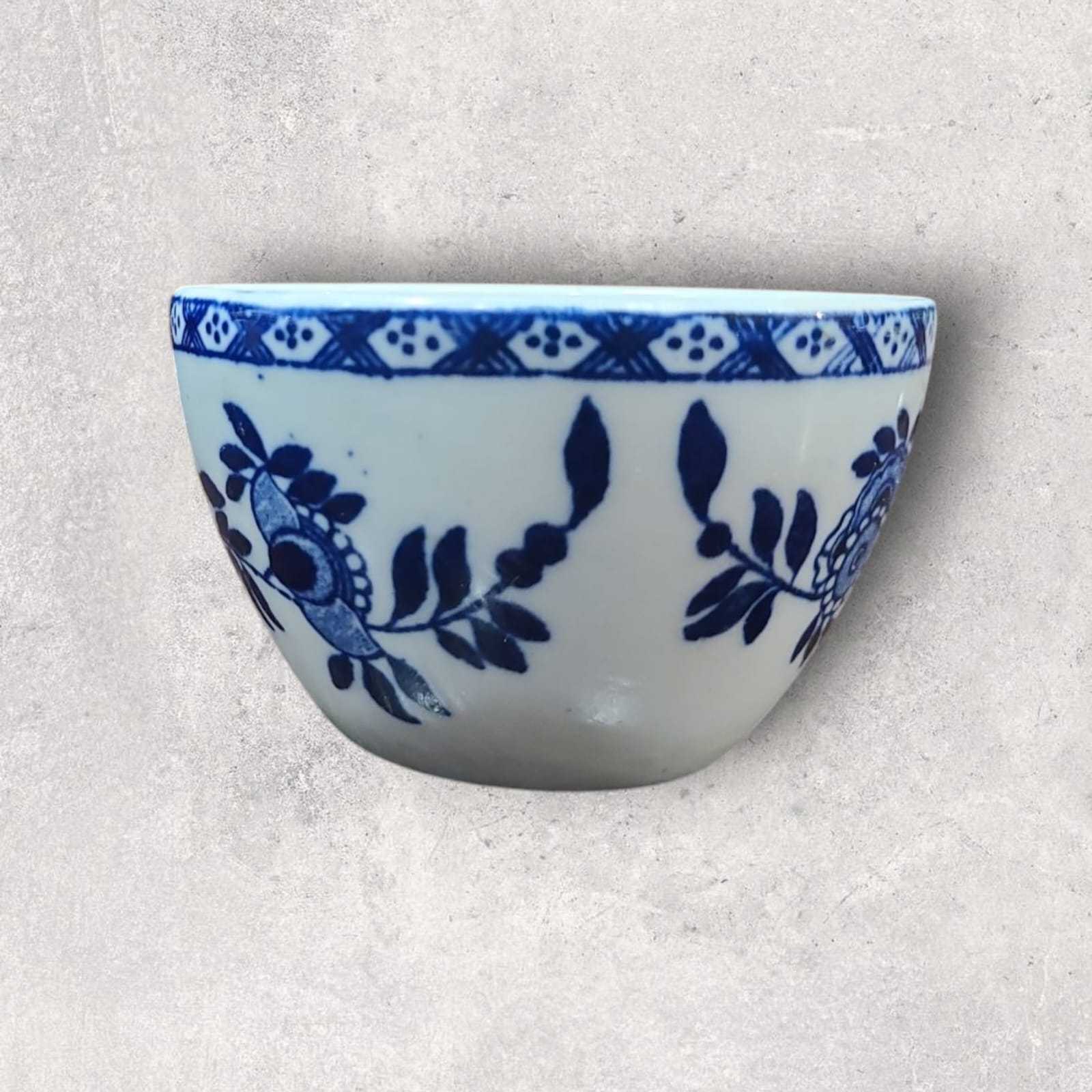 Detalle de la decoración en azul sobre porcelana blanca, resaltando los intrincados patrones hechos a mano.