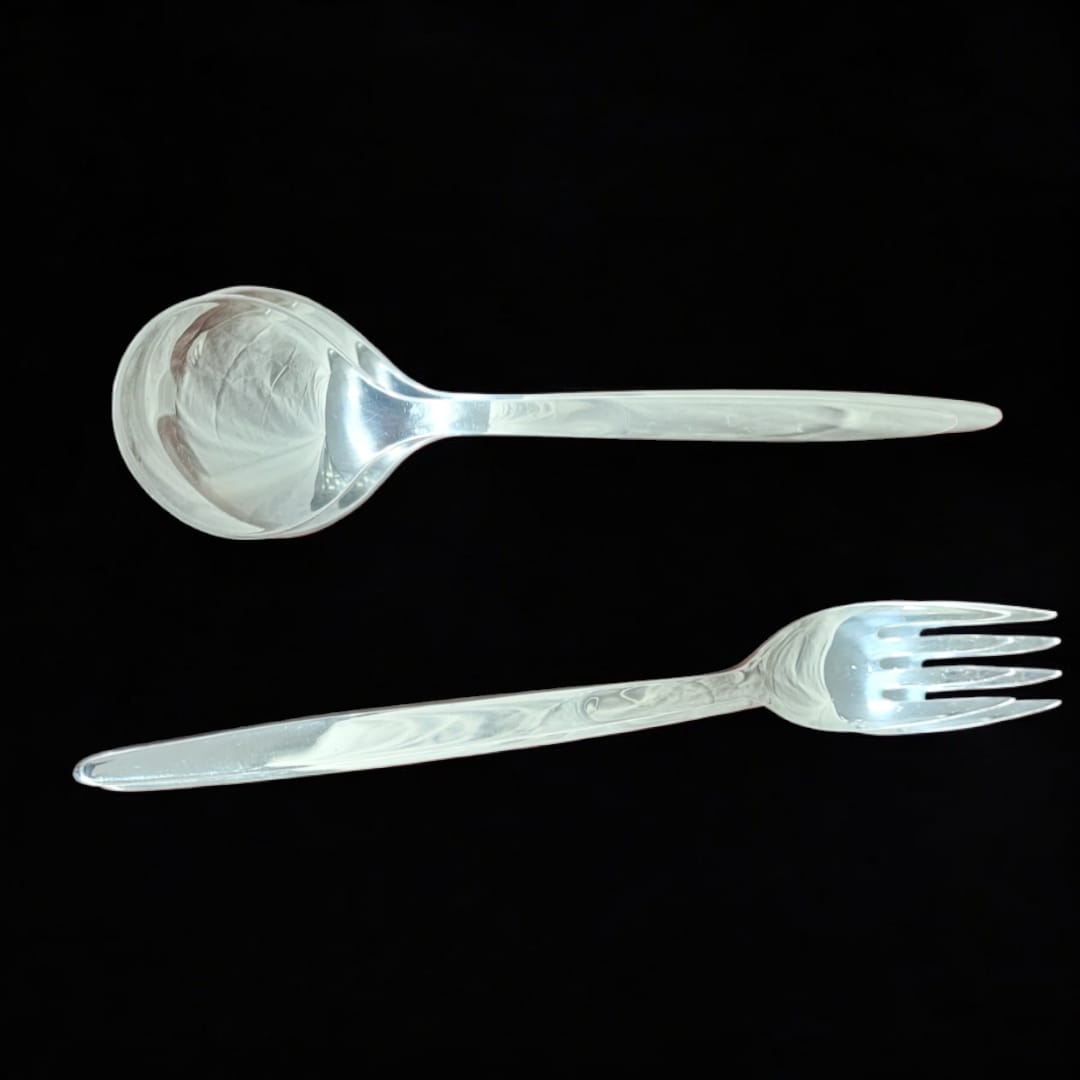 Set de cubiertos para ensalada en metal plateado, compuesto por cuchara y tenedor. Diseño sofisticado y funcional para la mesa.