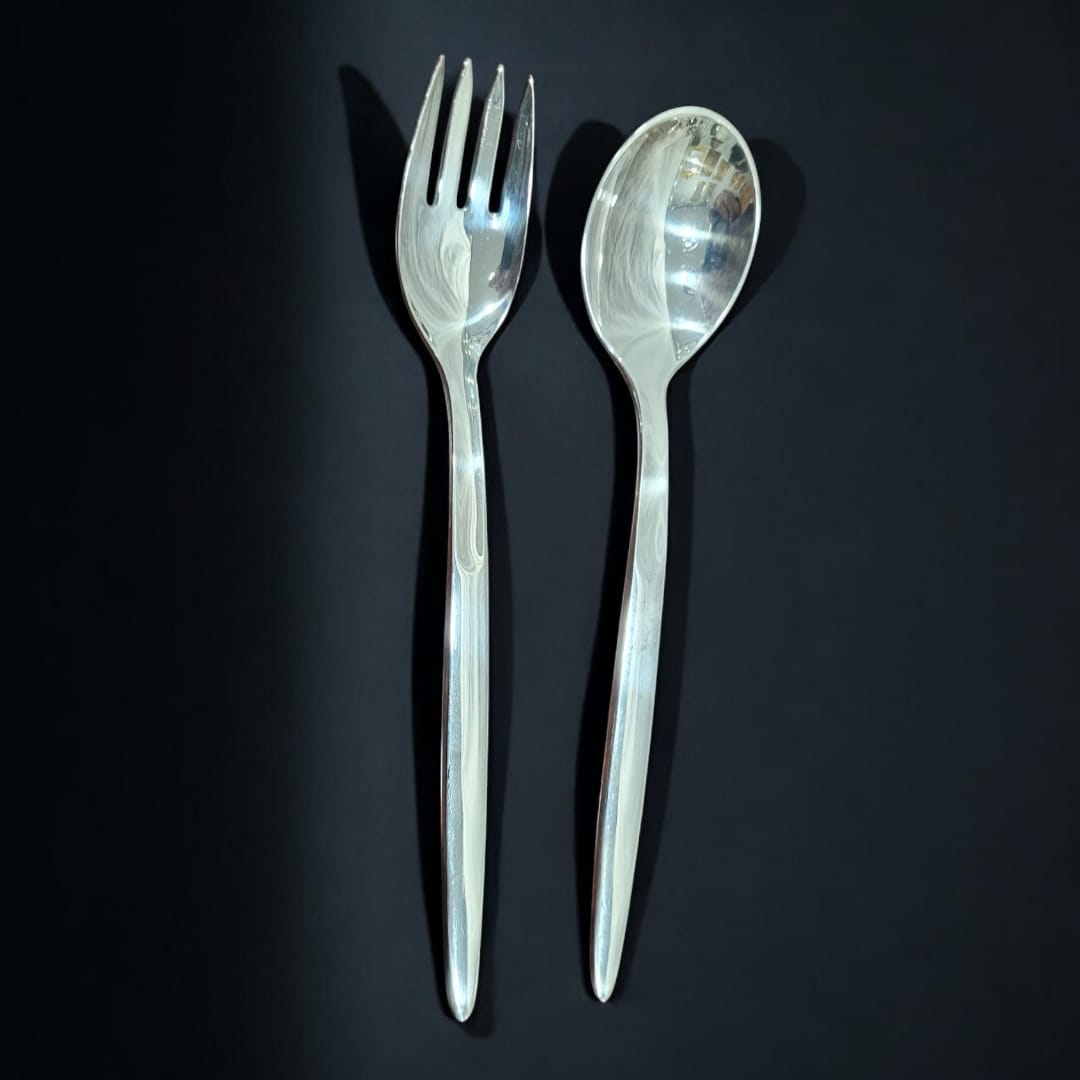 Cuchara y tenedor para ensalada en metal plateado, con acabado brillante y diseño moderno. Perfecto para complementar la vajilla elegante.