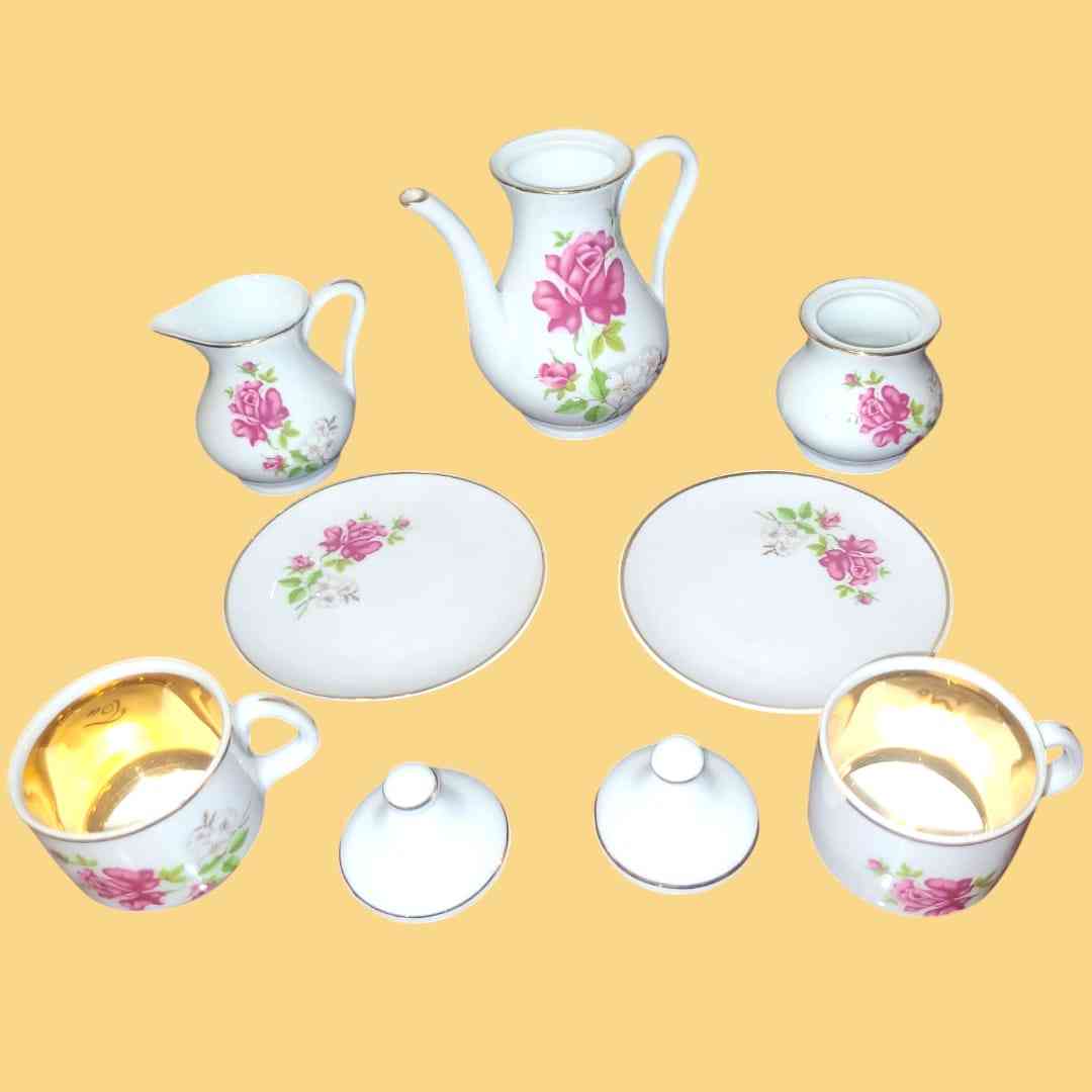 Juego de café 'Tú y Yo' de porcelana con diseño floral y detalles dorados, incluye piezas desmontadas para decoración.