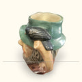 Jarra decorativa Royal Doulton Rip Van Winkle con asa en forma de rama y cuervo negro. Detalles pintados a mano en porcelana de colección exclusiva.