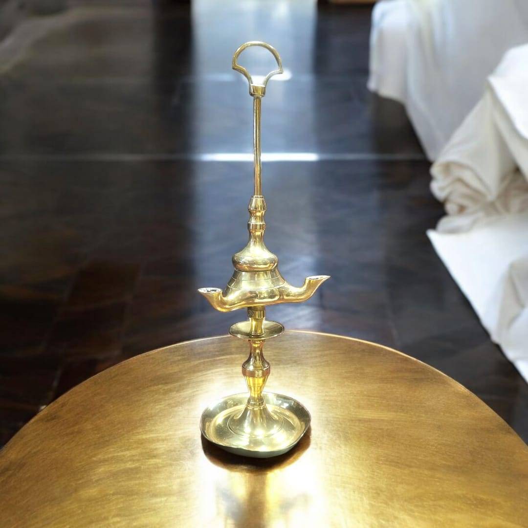 Decoración con velón antiguo de aceite de 3 brazos en metal dorado, pieza única para iluminar espacios con estilo retro.