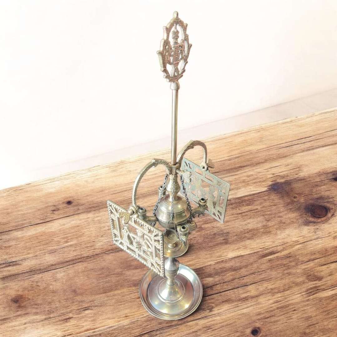 Velón de metal dorado decorativo con símbolos rituales únicos sobre mesa rústica. Ideal para decoración espiritual en hogar o altar.