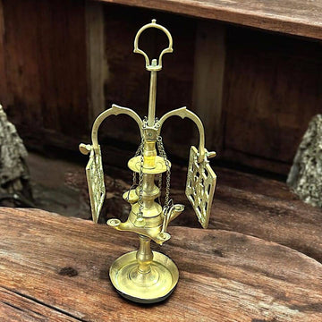 Velón pequeño metal con diseño clásico y calado artesanal, ideal para decoración única en interiores rústicos o vintage.