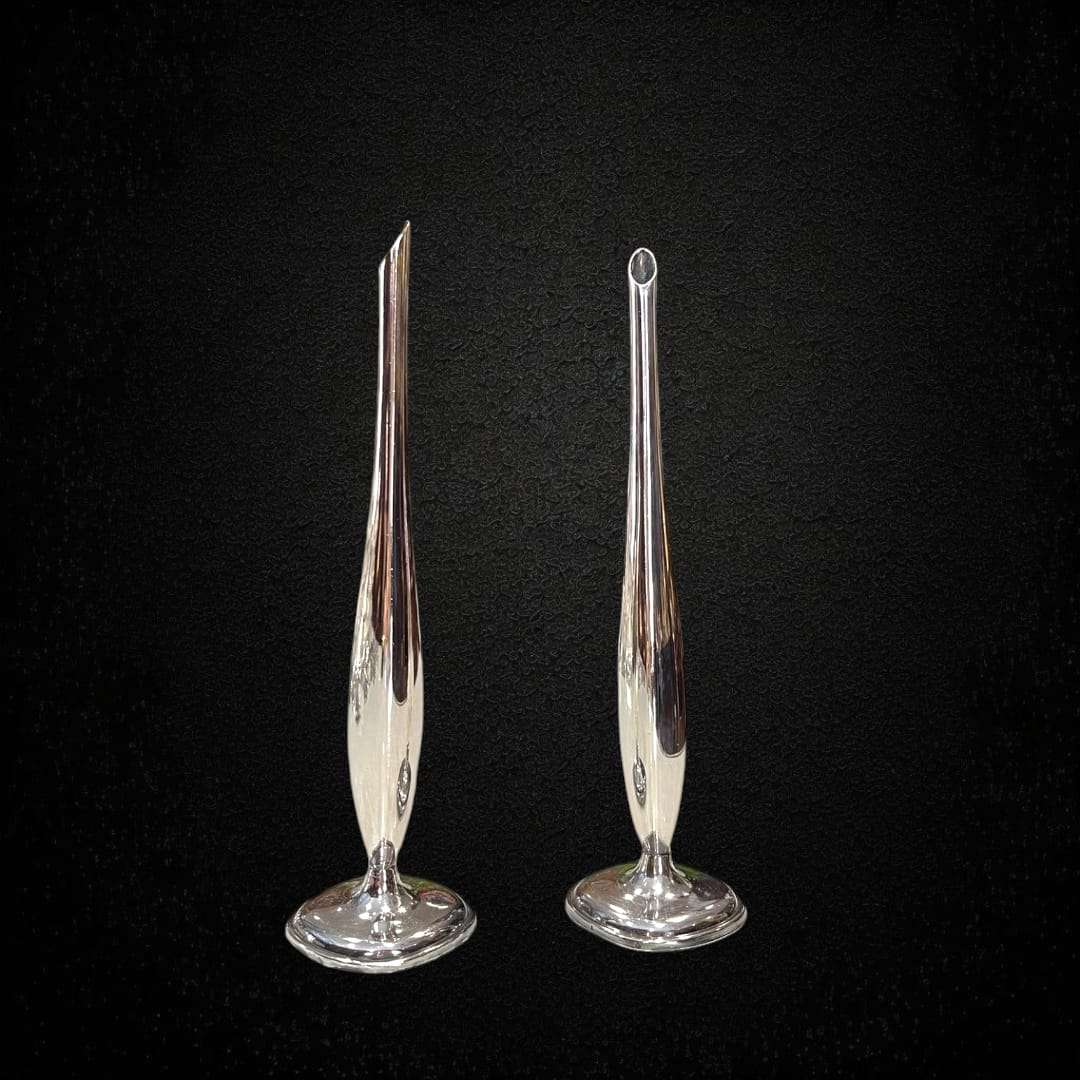 Elegante pareja de violeteros de metal plateado para decoración clásica.