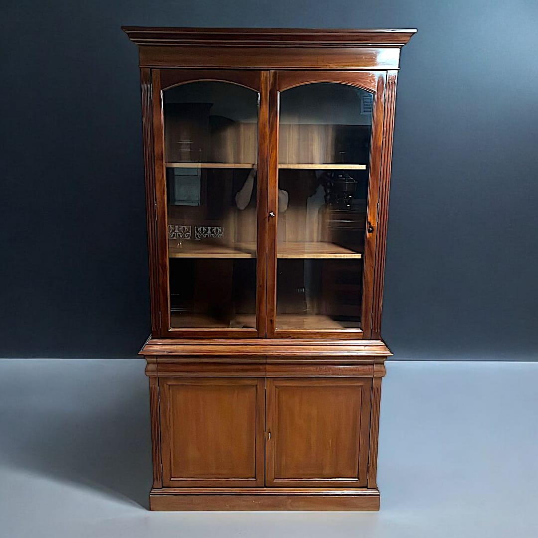 Vitrina de madera con puertas de cristal clásicas, ideal para decoración de interiores. Diseño elegante con estantes visibles y acabado caoba.
