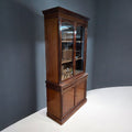 Vitrina de madera vista lateral con puertas de cristal, diseño clásico y funcional para decoración de interiores en estilo tradicional.