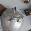 Olla de aluminio con tapa y asas remachadas, ideal para decoración de cocina vintage. Pieza antigua perfecta para estilo retro en el hogar.