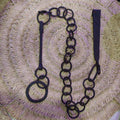 Cadena forjada - LLares de hierro forjado para colgar calderos sobre fondo de mimbre, ideal para decoración rústica de chimeneas.