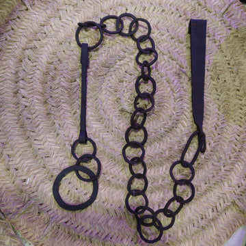 Cadena forjada - LLares de hierro forjado para colgar calderos sobre fondo de mimbre, ideal para decoración rústica de chimeneas.