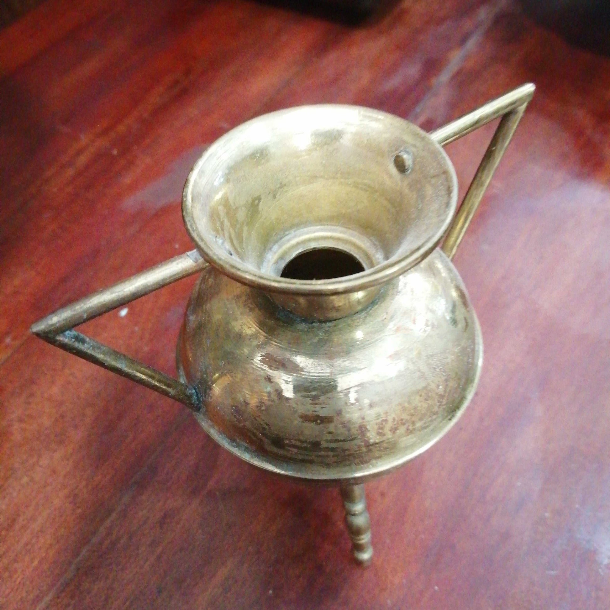 Macetero pote gallego de metal con tres patas, ideal decoración rústica en interiores. Diseño antiguo con acabado metálico brillante.