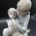 Detalle cercano de figura de porcelana niño y niña sentada | Elegancia y calidad, muestra expresión tierna y acabado fino artesanal.