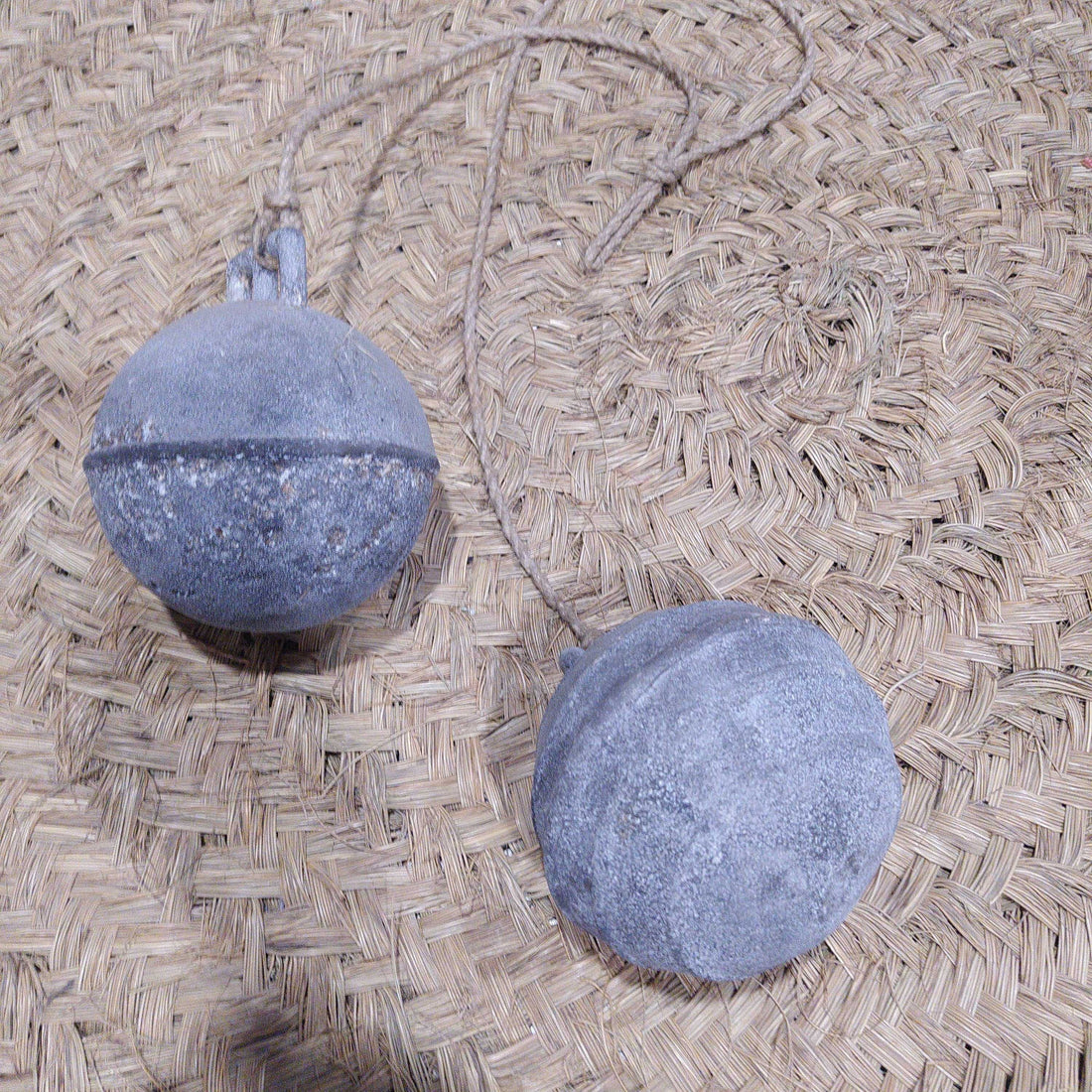 Boyas Náuticas de Calamina con acabado envejecido sobre fondo de fibra natural, ideales para decoración náutica vintage en el hogar o jardín.