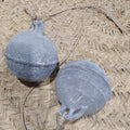 Boyas Náuticas de Calamina con acabado envejecido sobre fondo de fibra natural, ideales para decoración náutica vintage en hogar o jardín.
