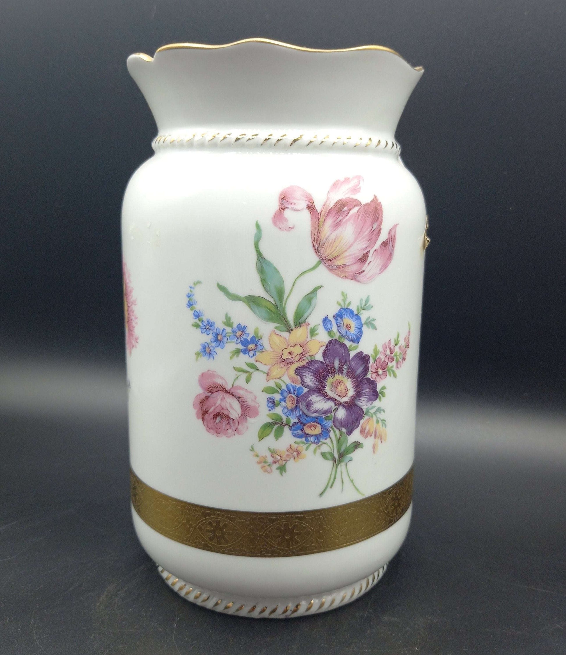 Jarrón de porcelana pintado a mano de excelente calidad con flores multicolores y detalles dorados, ideal para decoración elegante del hogar.