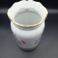Jarrón de porcelana pintado a mano de excelente calidad con detalles florales y borde dorado, ideal para decoración elegante de interiores.