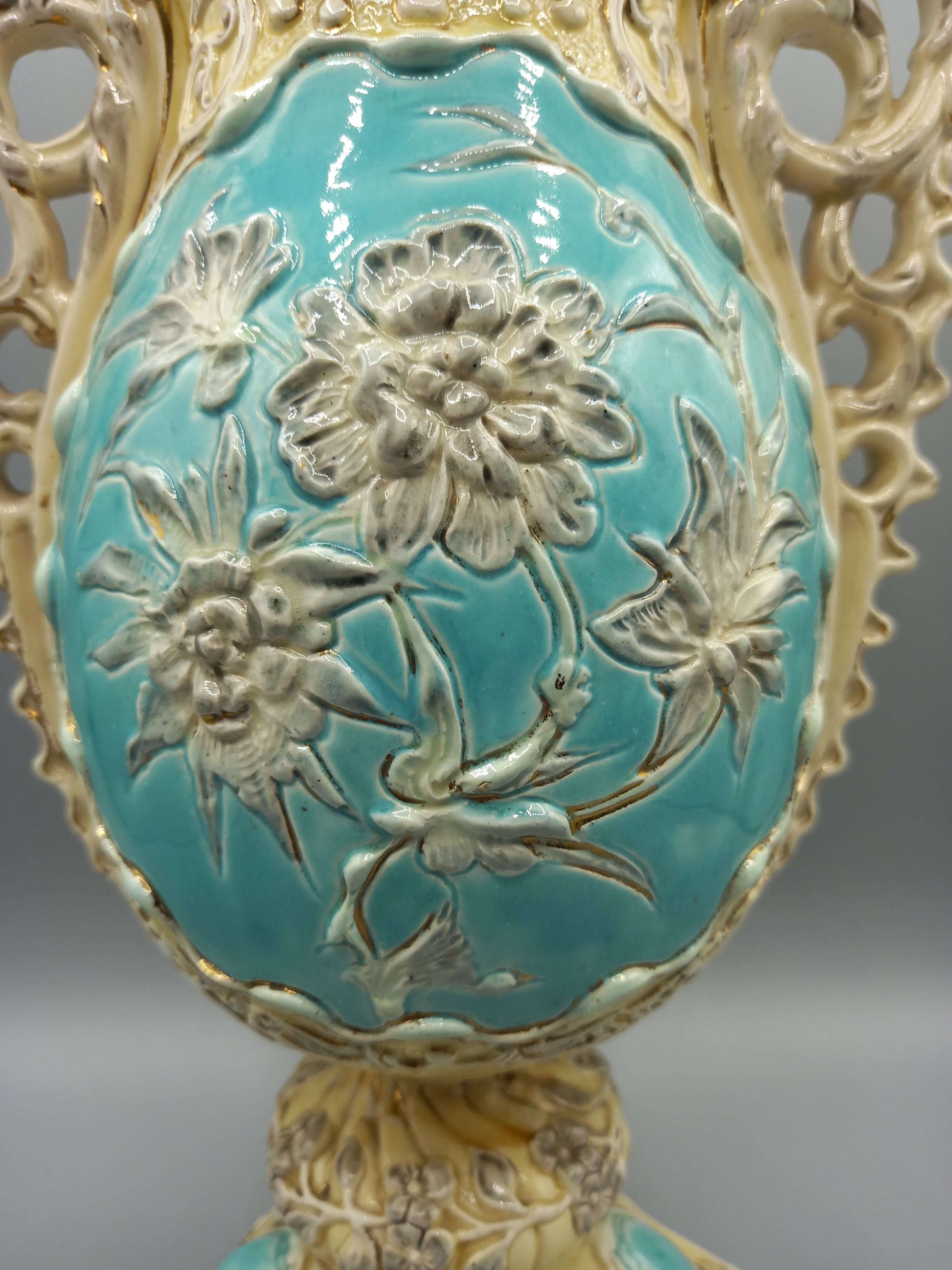 Jarron de ceramica esmaltado con detalles decorativos en relieve floral sobre fondo turquesa, ideal para decoracion vintage en el hogar.