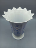 Jarrón de porcelana Capeans con diseño floral azul y borde ondulado, ideal para decoración elegante en el hogar o jardín.