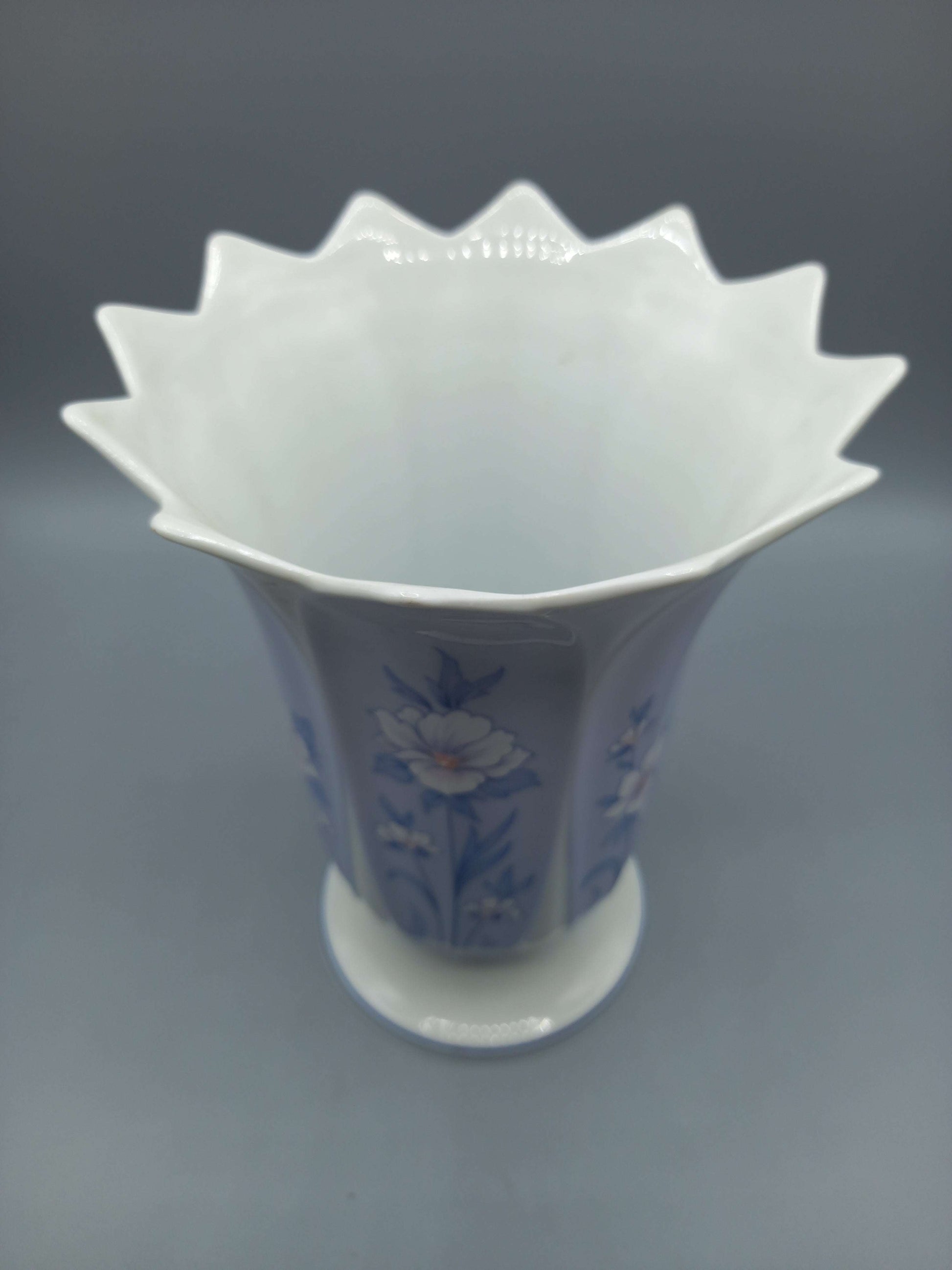 Jarrón de porcelana Capeans con diseño floral azul y borde ondulado, ideal para decoración elegante en el hogar o jardín.