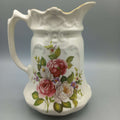 Jarra de porcelana inglesa con diseño floral en relieve, ideal para decoración vintage en el hogar. Antigüedad y calidad destacada para coleccionistas.
