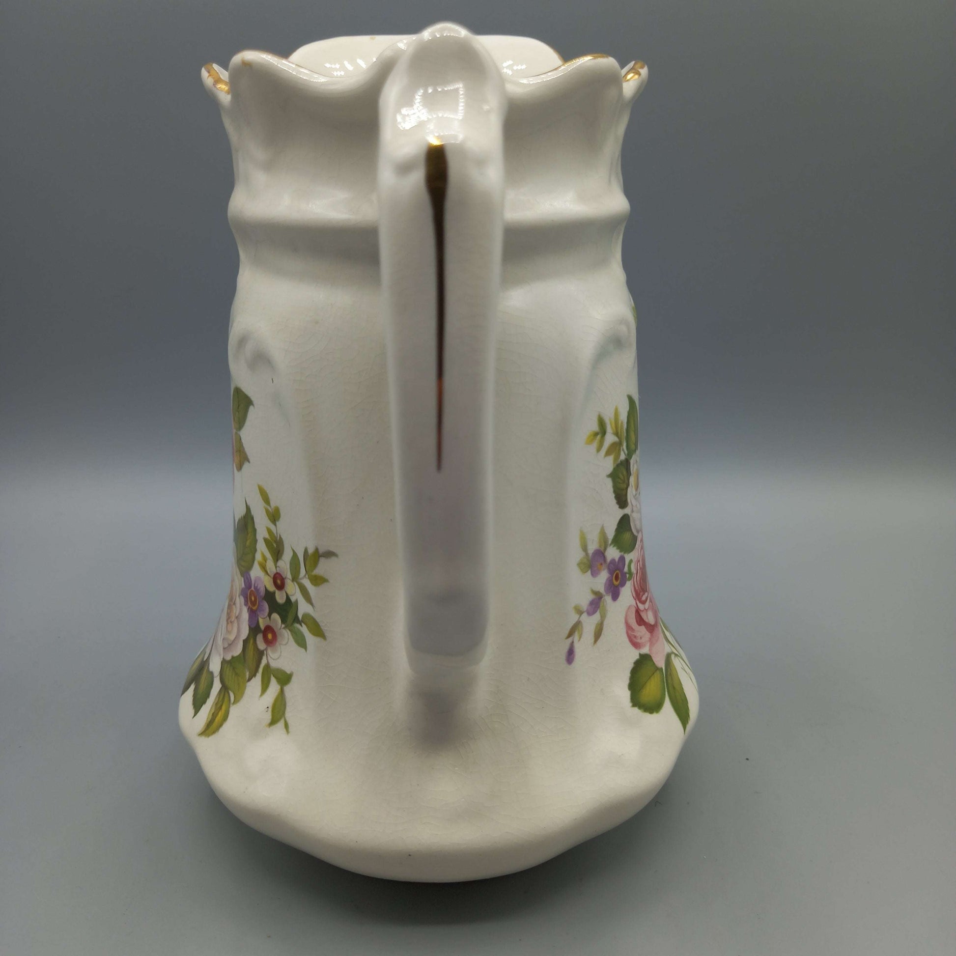 Jarra de porcelana inglesa con diseño floral vintage, ideal para decoración de interiores con estilo clásico y elegante. Antigüedad y calidad destacada.