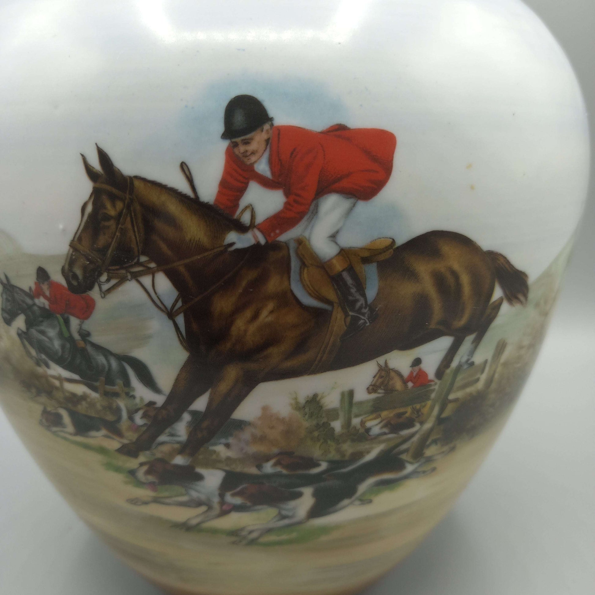 Tibor de porcelana pintado a mano con escena de cacería inglesa, jinete en caballo marrón y perros de caza en paisaje campestre. Decoración exclusiva para el hogar.