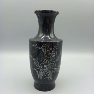 Florero de mármol tallado con diseño elegante de flores grabadas, ideal para decoración clásica en el hogar. Acabado artesanal en tono oscuro.