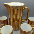 Jarra de porcelana San Claudio con acabado dorado brillante y 6 jarritas a juego. Ideal para decoración vintage en hogar o colección clásica.