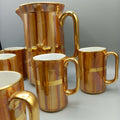 Jarra de porcelana San Claudio con acabado dorado y 6 jarritas a juego, ideal para decoración clásica en hogar o colección vintage.