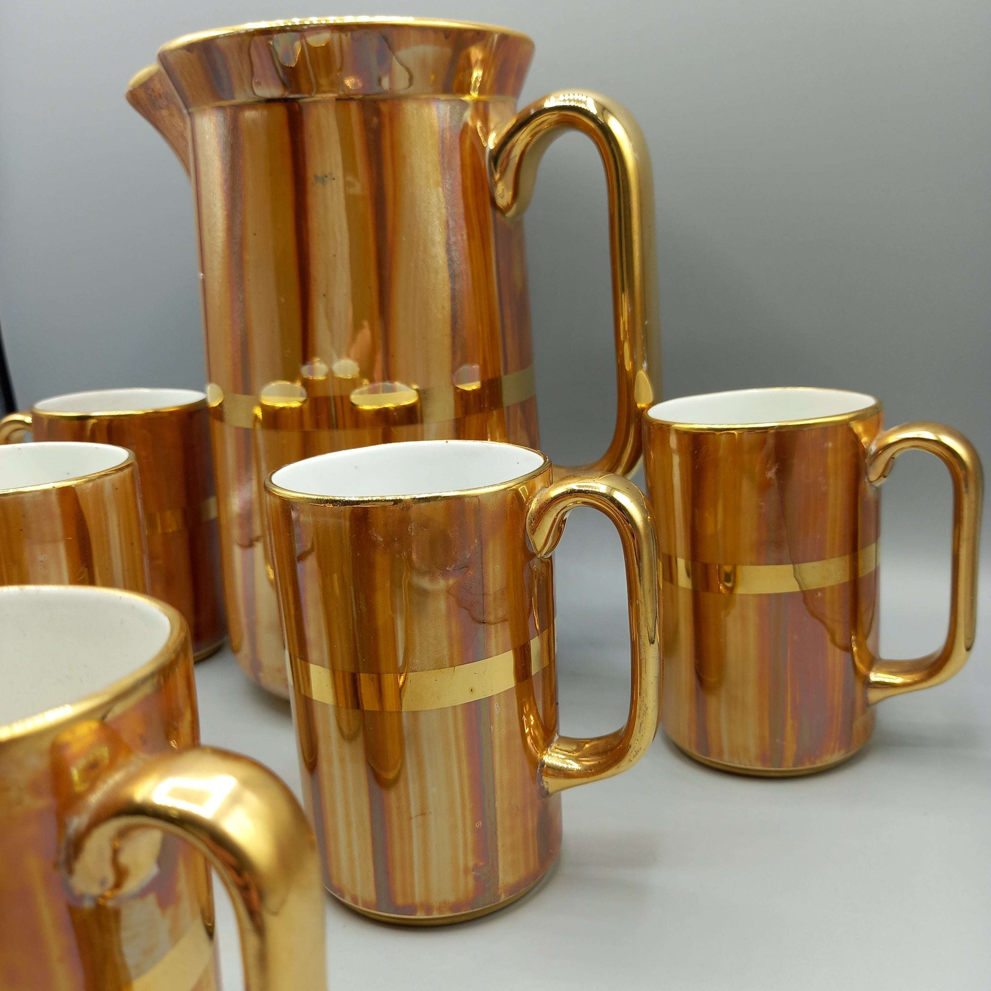 Jarra de porcelana San Claudio con acabado dorado y 6 jarritas a juego, ideal para decoración clásica en hogar o colección vintage.