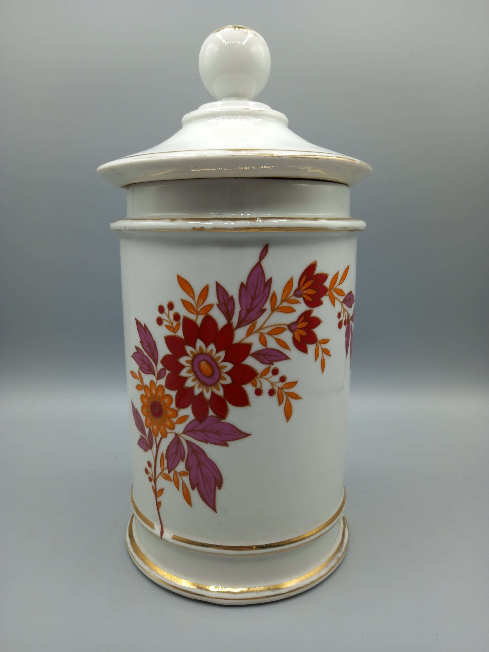 Tarro-Albarelo de Farmacia Antiguo en Porcelana con Decoración Floral en tonos rojos y púrpuras, ideal para decoración vintage en el hogar.