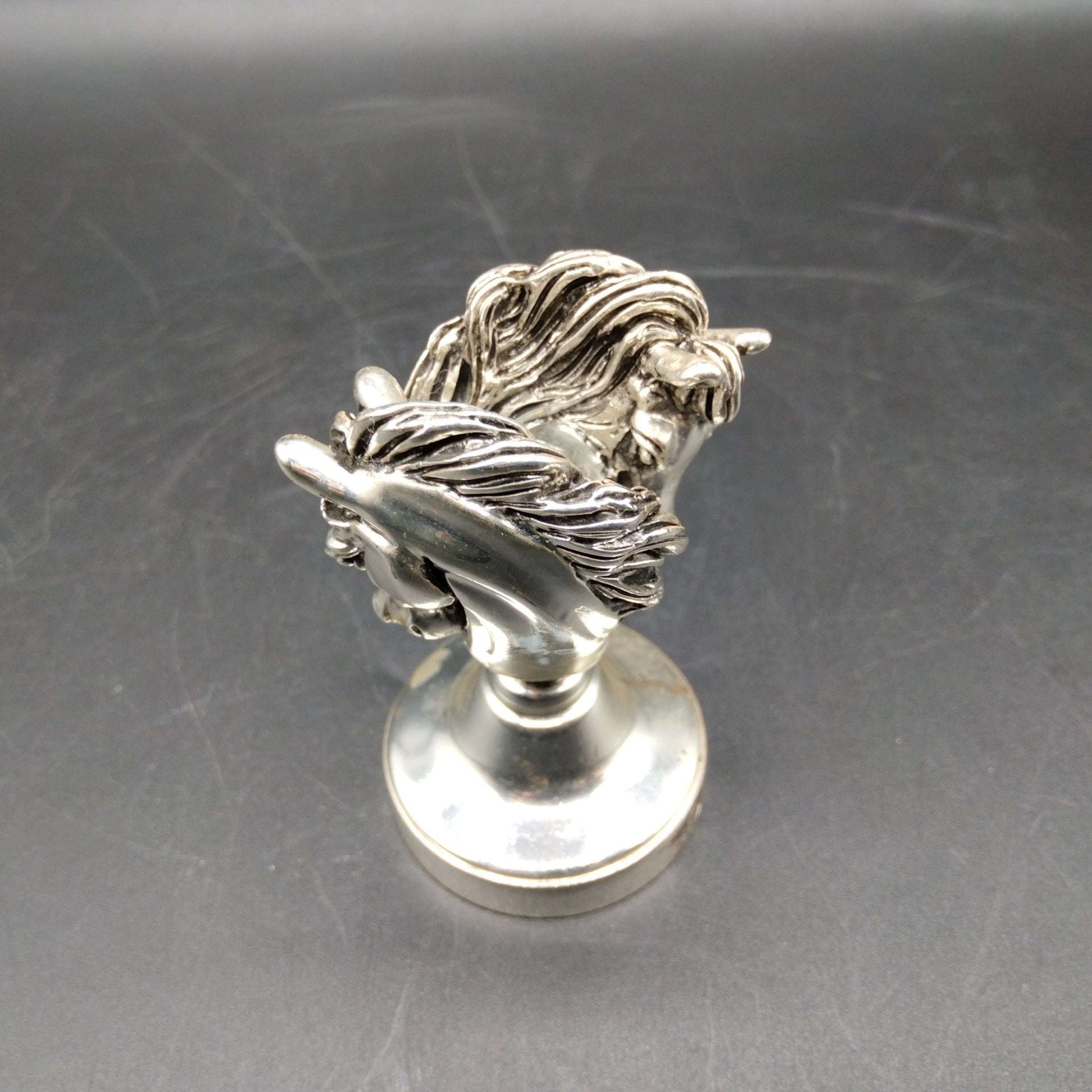 Sello de lacre caballos en metal plateado de 7cm, con diseño detallado de dos cabezas de caballo. Ideal para decoración vintage y coleccionistas.