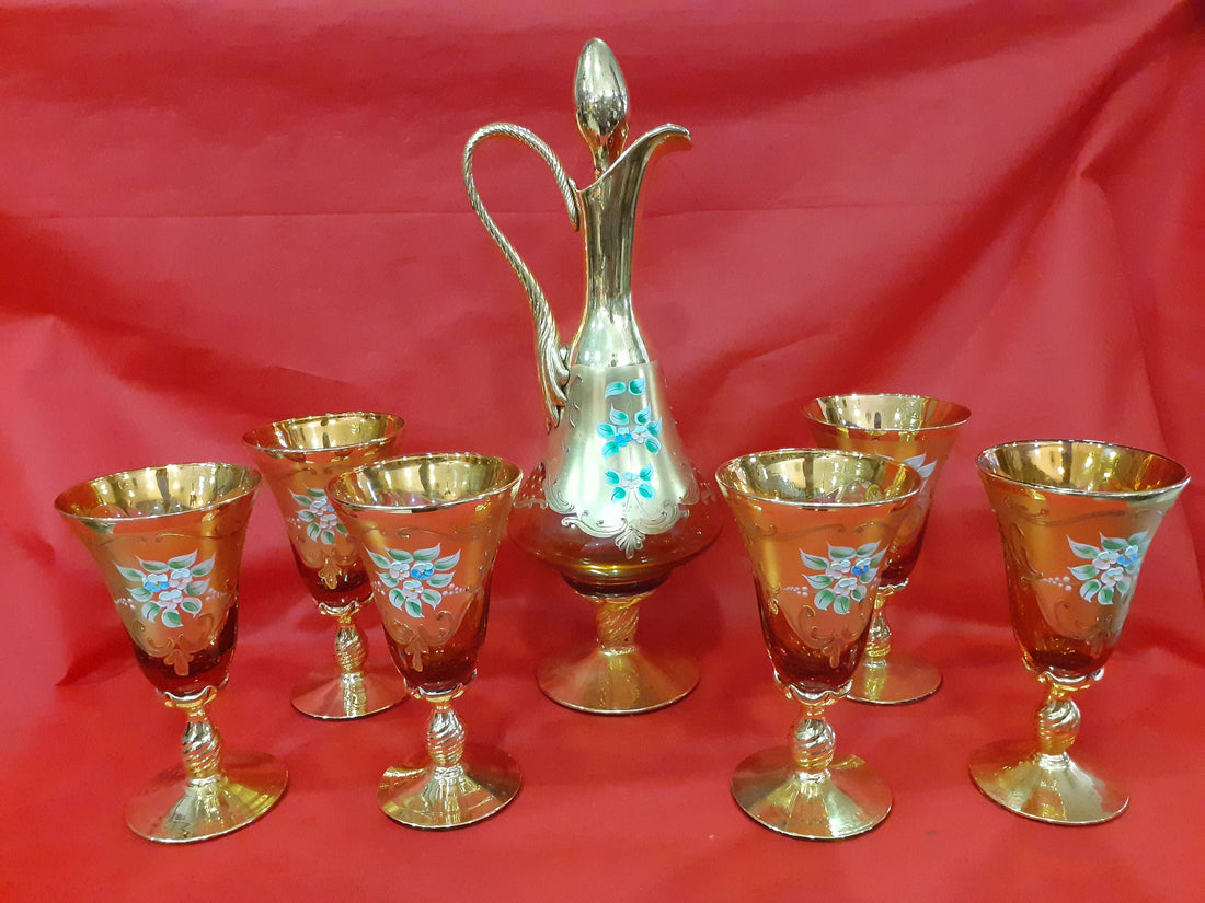 Botella de licor Murano con 6 copas exquisitas, pintadas a mano en cristal dorado con detalles florales, decoración vintage elegante.