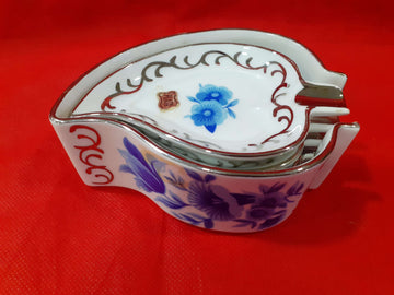 Juego completo de ceniceros de porcelana con decoración floral azul y detalles en hilo de plata sobre fondo rojo. Ideal para decoración elegante.