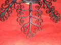 Mortero con filigranas antiguas de hierro forjado sobre fondo rojo, ideal como decoración de pared única para el hogar. Diseño ornamental exclusivo.