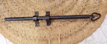 Pestillo de puerta antiguo de hierro forjado con diseño clásico, ideal para decoración rústica y seguridad en puertas de madera.