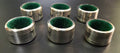 Set de 6 servilleteros de metal plateado con interior forrado en terciopelo verde, numerados del 1 al 6. Ideal para decoración de mesa elegante.