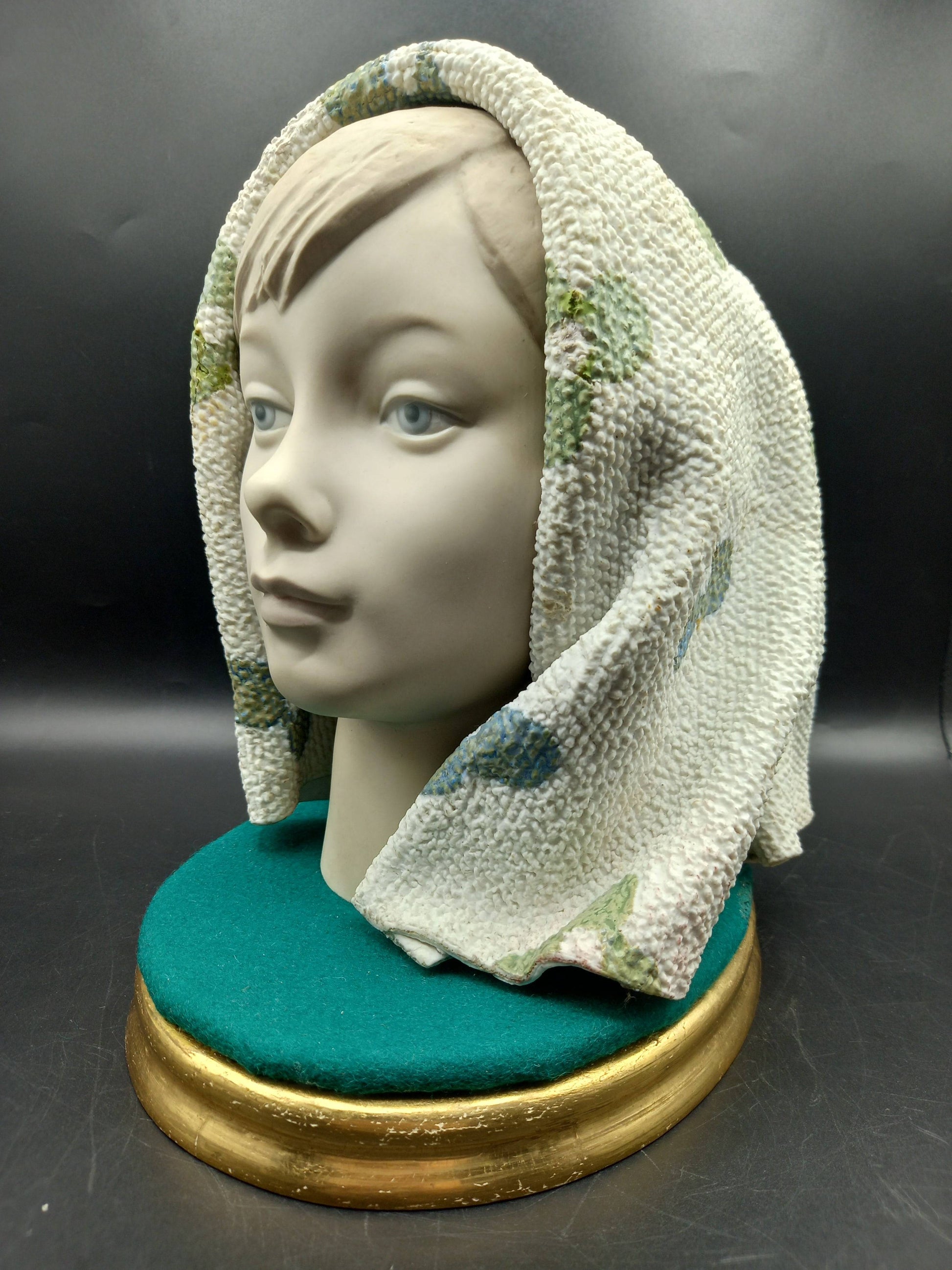 Escultura decorativa Lladró de niña con manta texturizada, acabados finos en porcelana, perfecta para coleccionistas de arte en casa.