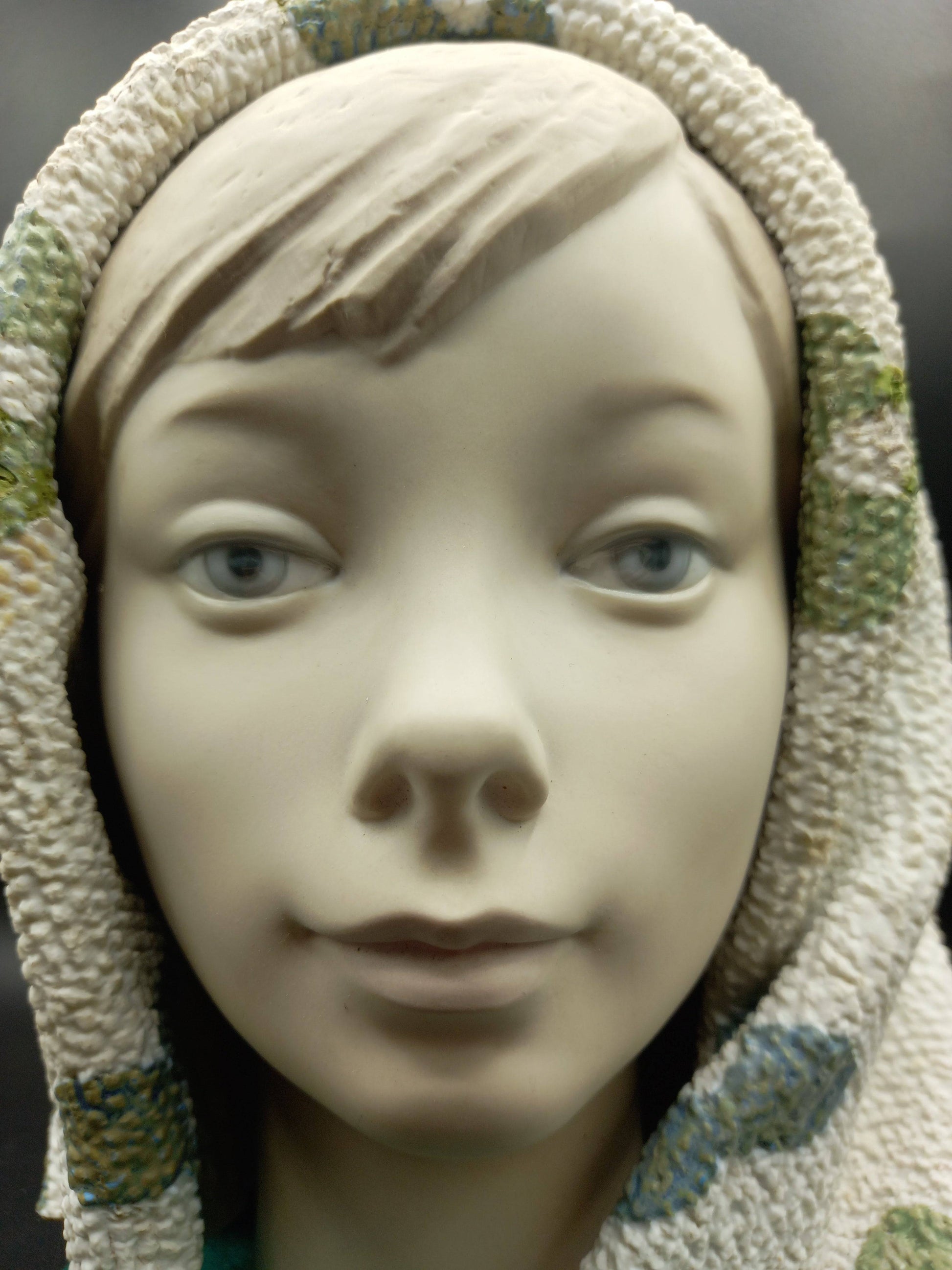 Primer plano de figura Lladró de chica con manta, detalles realistas en porcelana de alta calidad, ideal para decoración artística.