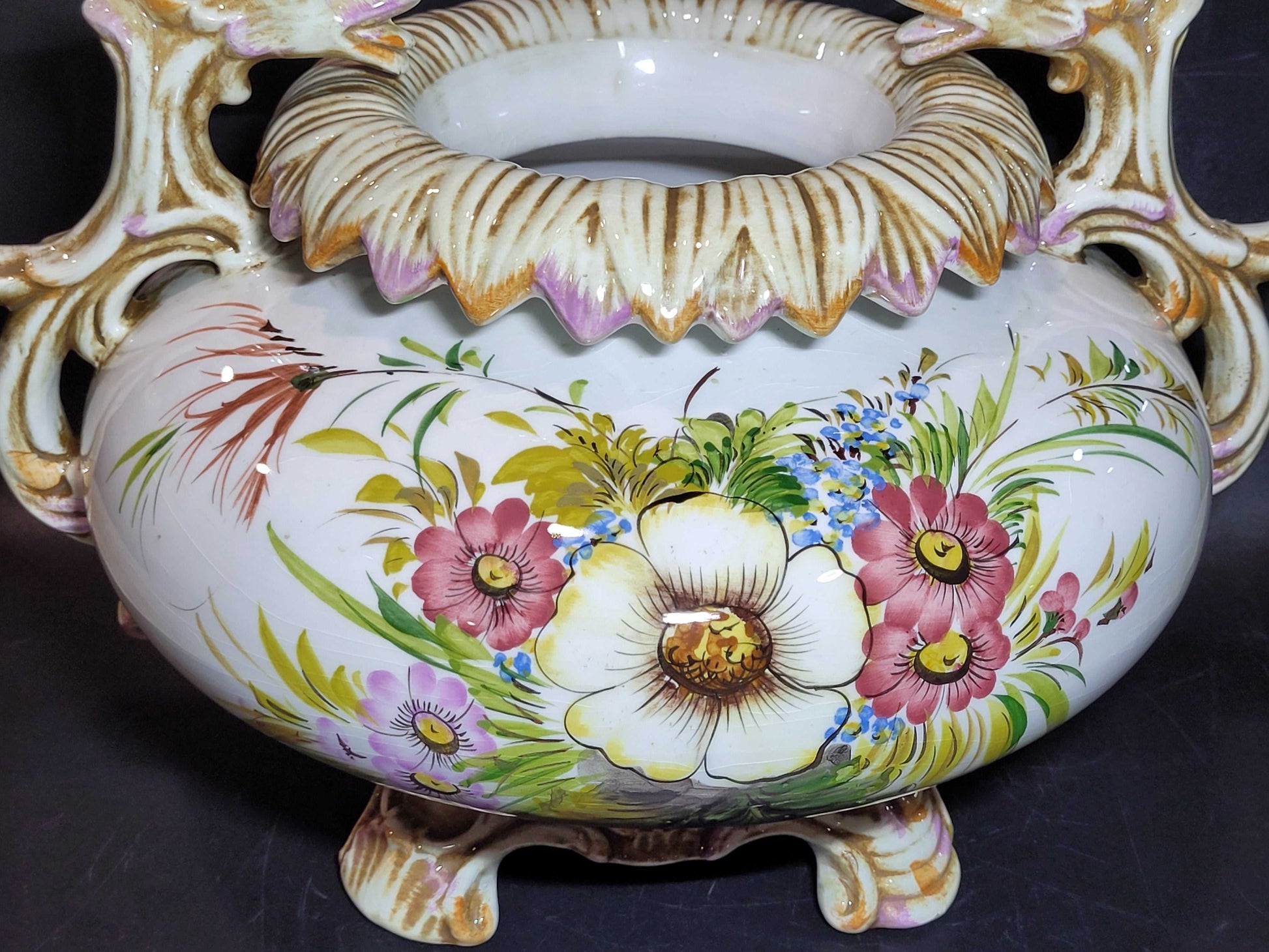 Detalle de centro de mesa de porcelana pintado a mano con flores en tonos vivos. Decoración refinada para el hogar o coleccionistas de antigüedades.