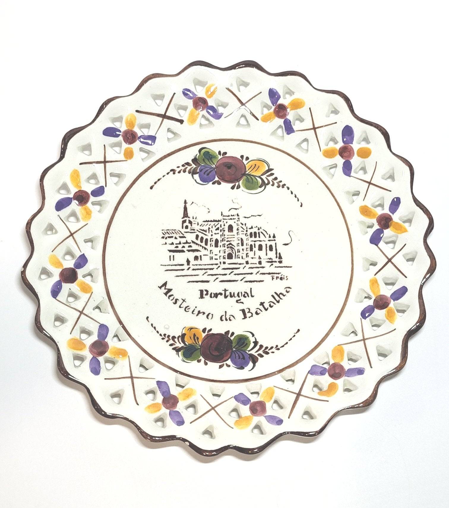 Plato decorativo portugués con ilustración del Mosteiro de Batalha, borde calado y detalles florales pintados a mano, ideal para colgar.