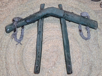 Yugo de costillas en madera de encina con refuerzos de hierro sobre fondo de esparto. Ideal para decoración rústica en hogar o jardín.