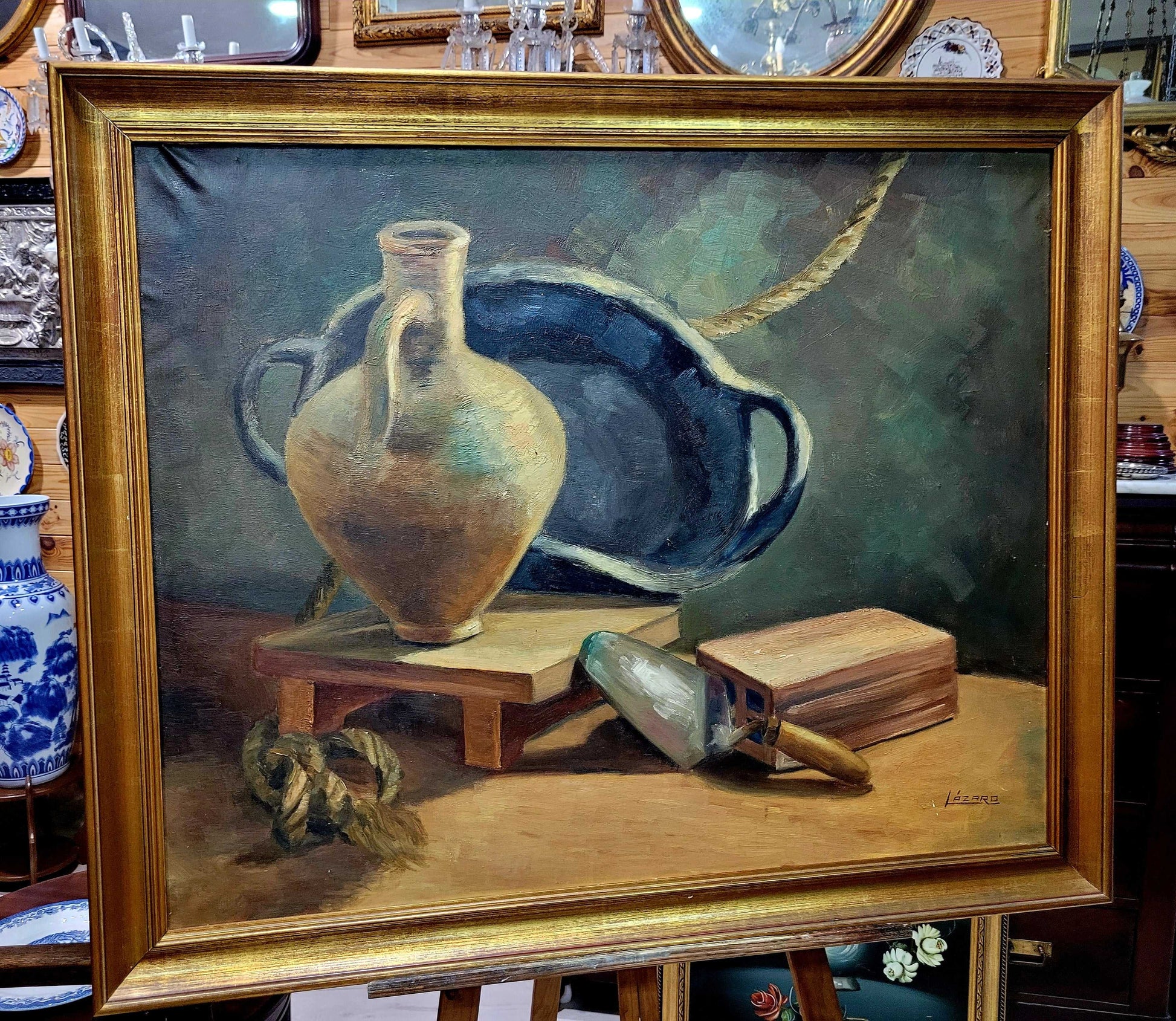 Pintura al óleo de bodegón con marco dorado antiguo, firmada por Lázaro, ideal para decoración vintage en hogar o galería de arte.