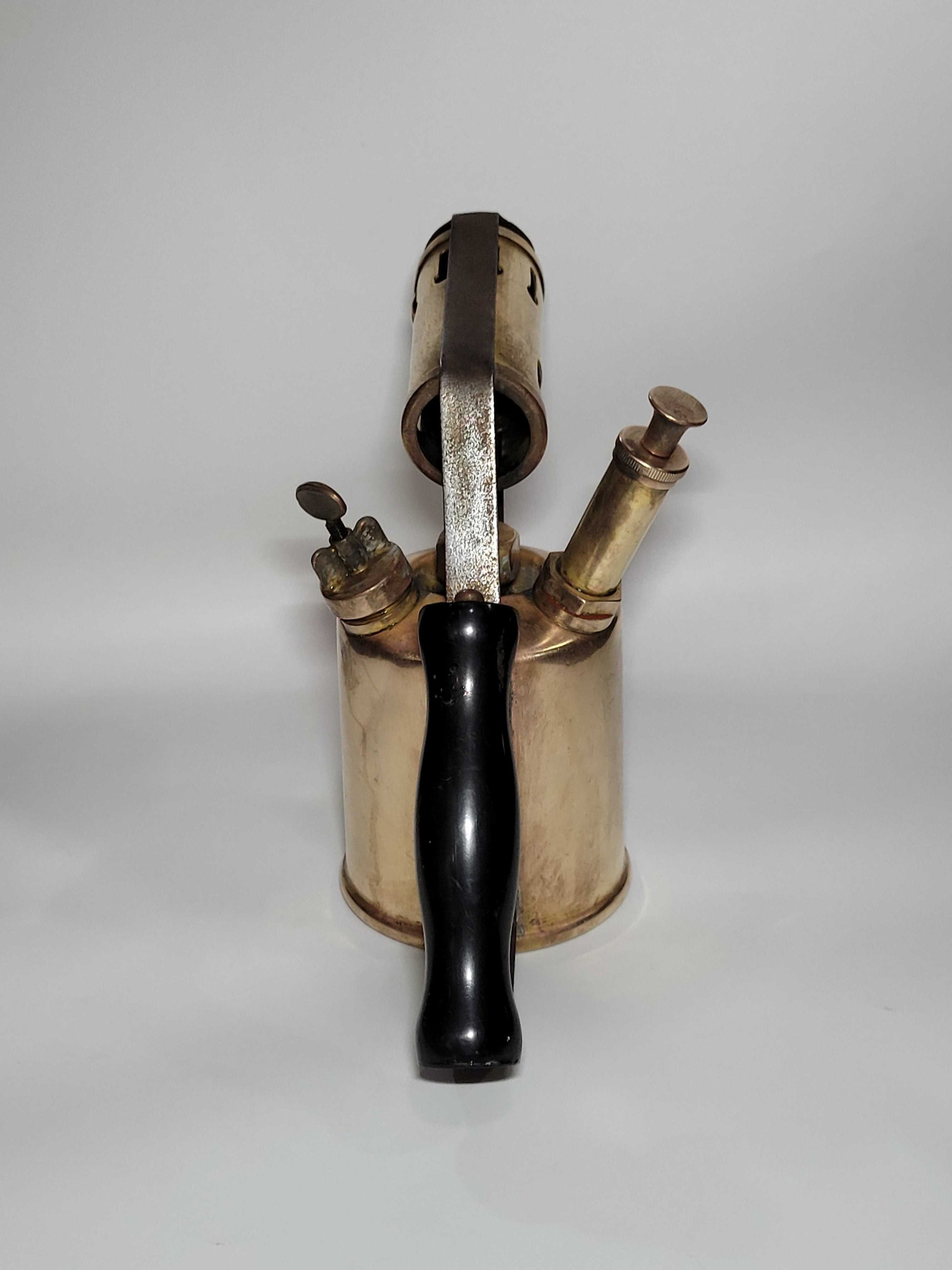 Lámparilla de fontanero antigua de colección con mango negro, estilo vintage en latón, ideal para decoración rústica o industrial.